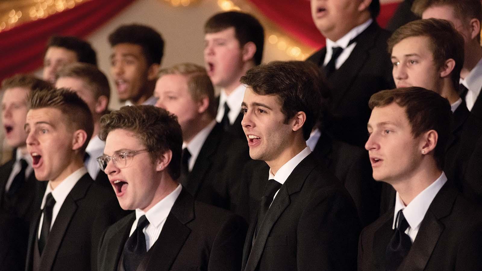 Closeup of men’s choir in tuxedos singing 