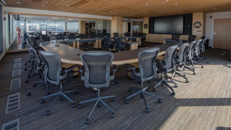 The Harold Schafer Leadership Center Boardroom features a large monitor at the front of the room with seating for several executives.