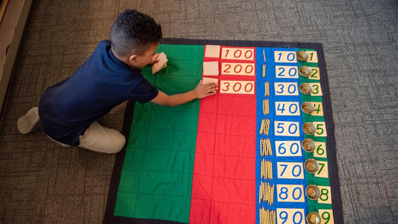 a Montessori lesson in math on a numbers mat