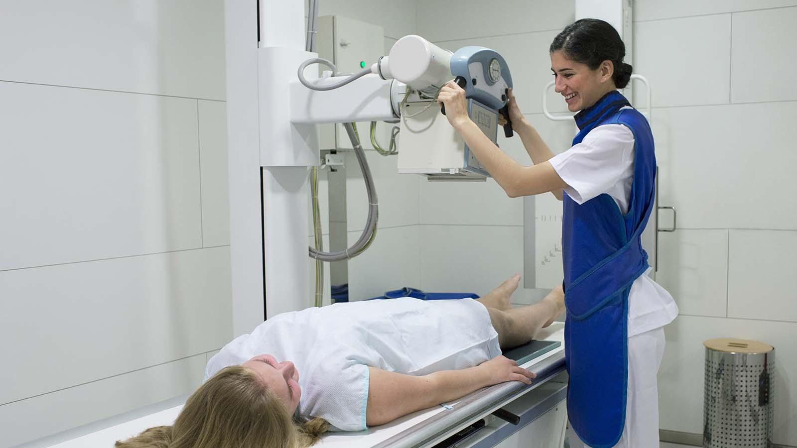 Radiologist with patient preparing machine for x-ray