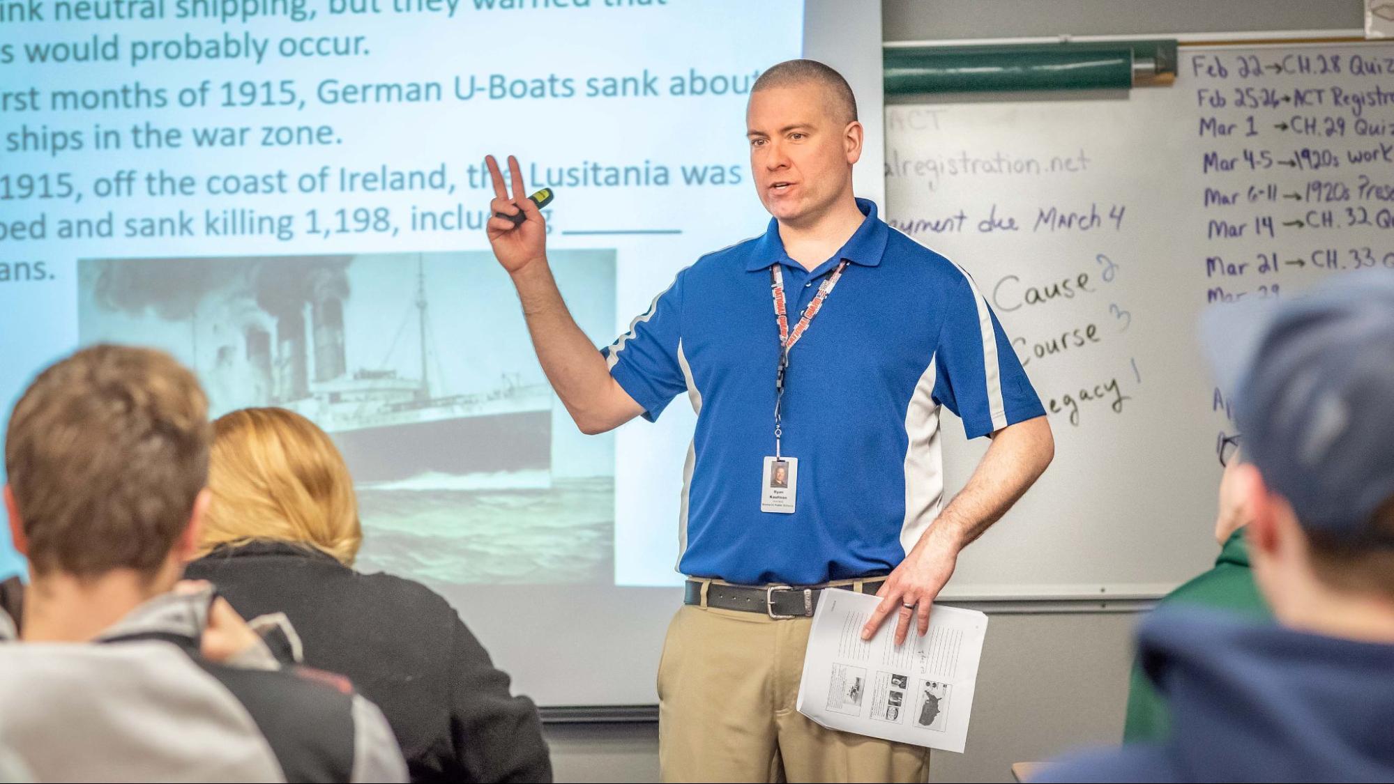 Social studies teacher in front of class teaching high school students