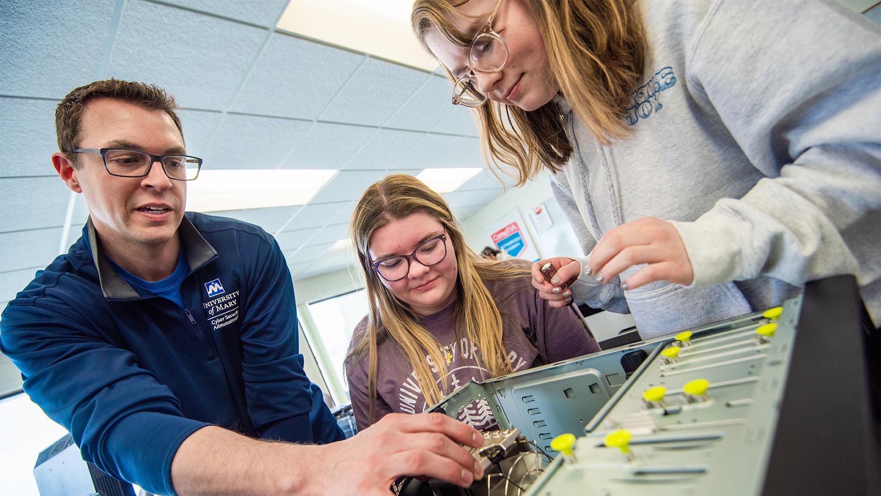 Students breaking down a computer