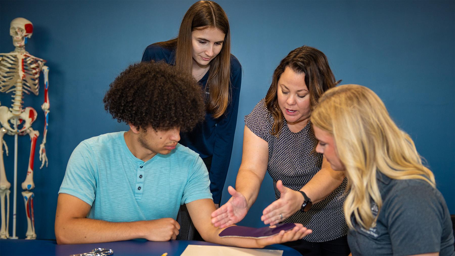 students learning how to properly wrap an arm brace.