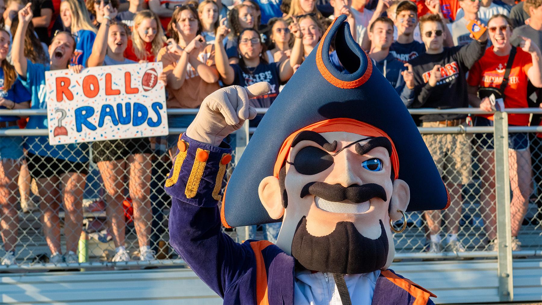 Max at a Football game with cheering students in the background.