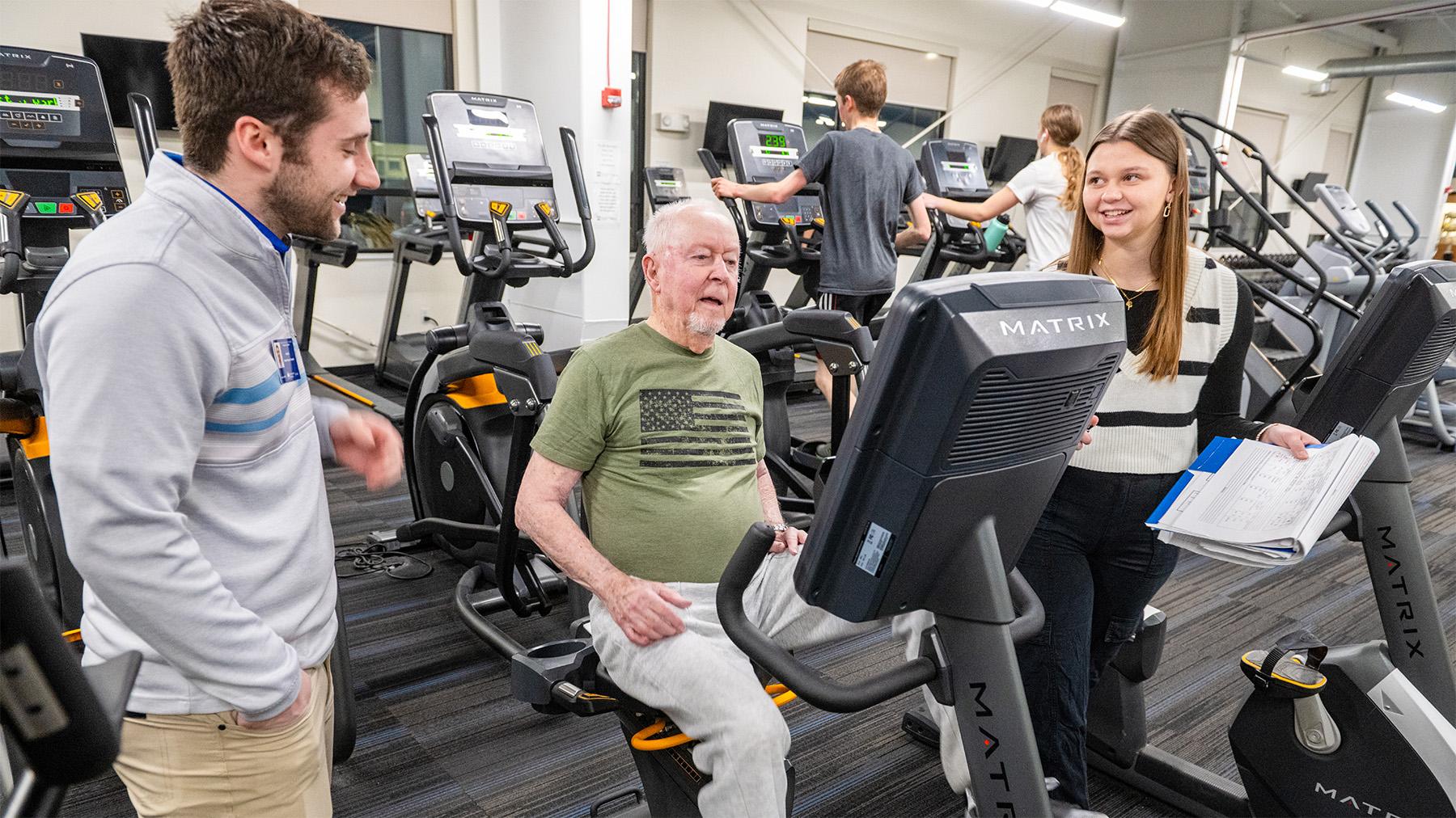 Students working with an elderly man at the Exercise Science Clinic